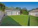 Spacious two-car garage featuring white doors, complemented by a lush lawn and a clear blue sky at 13045 Marbled Godwit Rd, Weeki Wachee, FL 34614