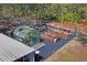 A greenhouse and outdoor garden with garden beds sit in a fenced yard with mature trees at 13045 Marbled Godwit Rd, Weeki Wachee, FL 34614