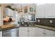 Stylish kitchen featuring white cabinets, granite countertops, and stainless steel appliances at 13045 Marbled Godwit Rd, Weeki Wachee, FL 34614