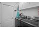 Laundry room with appliances, storage cabinets, and iron board hanging on the wall at 13045 Marbled Godwit Rd, Weeki Wachee, FL 34614