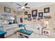Inviting living room features a plush white sectional sofa, decorative wall art, and a ceiling fan at 13045 Marbled Godwit Rd, Weeki Wachee, FL 34614