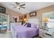 Bright main bedroom with luxury white furnishings, ceiling fan, and view of backyard pool at 13045 Marbled Godwit Rd, Weeki Wachee, FL 34614