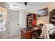 Office area with a wooden desk, bookcase, ceiling fan, neutral walls, and travertine tile flooring at 13045 Marbled Godwit Rd, Weeki Wachee, FL 34614
