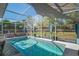 The screened-in pool features a clear blue pool, a hot tub and beautiful outdoor views at 13045 Marbled Godwit Rd, Weeki Wachee, FL 34614