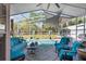 Outdoor pool and patio area with seating, ceiling fan, outdoor shades, and lush landscaping at 13045 Marbled Godwit Rd, Weeki Wachee, FL 34614