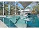 Stunning view of the clear blue pool in the screened in lanai and hot tub at 13045 Marbled Godwit Rd, Weeki Wachee, FL 34614