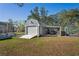 Outdoor storage shed with attached carport and a greenhouse in a grassy fenced backyard at 13045 Marbled Godwit Rd, Weeki Wachee, FL 34614
