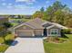 Aerial view of a well-maintained home with three-car garage, landscaped front yard, and inviting curb appeal at 13619 Bee Tree Ct, Hudson, FL 34669