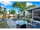 Waterfront backyard oasis with lush landscaping, a glass top table, and canal views at 13906 Barnard Ave, Hudson, FL 34667