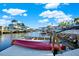 Dock view showcasing waterfront community, with boat lift and clear blue sky at 13906 Barnard Ave, Hudson, FL 34667