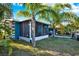 Exterior view of a home with a screened-in porch and a spacious backyard with mature palm trees at 13906 Barnard Ave, Hudson, FL 34667