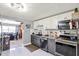 Modern kitchen with gray and white cabinets, granite countertops, and stainless steel appliances at 13906 Barnard Ave, Hudson, FL 34667