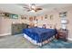 Comfortable bedroom with a ceiling fan, wood-look flooring, and colorful decor at 13906 Barnard Ave, Hudson, FL 34667