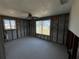 Bedroom interior with two windows and a ceiling fan, featuring block wall construction at 13930 Berkowitz Ave, Hudson, FL 34667