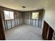 Bedroom interior with two windows and a ceiling fan, featuring block wall construction at 13930 Berkowitz Ave, Hudson, FL 34667