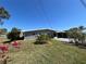 Charming home featuring a carport, well-maintained lawn, and vibrant red flowers enhancing the property's curb appeal at 13930 Berkowitz Ave, Hudson, FL 34667