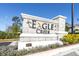 Stone entrance sign for Eagle Creek community with manicured landscaping and clear blue sky background at 1436 Gopher Loop, Tarpon Springs, FL 34689