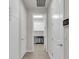 Bright hallway leading to laundry room with white doors and modern tile flooring at 1436 Gopher Loop, Tarpon Springs, FL 34689