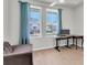 Home office with large windows providing natural light and wood-look floors for a comfortable workspace at 1436 Gopher Loop, Tarpon Springs, FL 34689