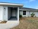 Inviting front entrance featuring a covered porch, modern lighting, freshly painted exterior, and tasteful landscaping at 1713 Walden Ct, Englewood, FL 34224