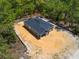 This birds eye view showcases the dark roof, surrounded by a perimeter line and the trees on the property at 18082 Parakeet Rd, Brooksville, FL 34614