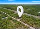 An aerial view pinpoints the home's wooded location accessible by a long driveway near a main road at 18082 Parakeet Rd, Brooksville, FL 34614