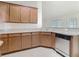 Well-lit kitchen with wood cabinets, stainless steel dishwasher and bright countertops at 2433 Fairview Rd, Spring Hill, FL 34609