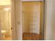 A walk-in closet includes wire shelving with an en-suite bathroom and a glass shower enclosure at 2568 W Brook Ln, Clearwater, FL 33761