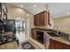 Corner view of the kitchen with granite countertops, mosaic backsplash, gas range, and view to the dining area at 2625 Micah Dr, Trinity, FL 34655