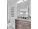 Bathroom showcasing a dual granite vanity, contemporary fixtures, and framed blue botanical art at 3975 Night Star Trl, Odessa, FL 33556