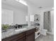 Bathroom featuring granite countertops, dark cabinets, and a shower with patterned curtains at 3975 Night Star Trl, Odessa, FL 33556