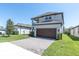 Two-story home featuring a brick driveway, attached two-car garage, and second-story balcony at 3975 Night Star Trl, Odessa, FL 33556