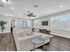 Bright and airy living room features a large sectional, dark wood floors, and recessed lighting at 3975 Night Star Trl, Odessa, FL 33556