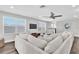 Bright living room showcasing a large sectional, ceiling fan, and multiple windows for natural light at 3975 Night Star Trl, Odessa, FL 33556
