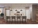 Modern kitchen showcasing a large center island with bar stool seating, pendant lighting, and sleek white cabinetry at 4112 Southern Valley Loop, Brooksville, FL 34601