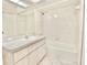 Bathroom features a vanity with a sink, a large mirror, and a shower and tub combination at 4429 Whitton Way, New Port Richey, FL 34653