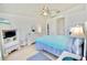 Bright bedroom features a ceiling fan, white furniture, light wood floors and relaxing decor at 4429 Whitton Way, New Port Richey, FL 34653
