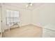 Bedroom features light wood floors, vaulted ceilings, a fan and a desk near the window at 4429 Whitton Way, New Port Richey, FL 34653
