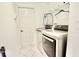 Functional laundry room with modern washer and dryer, white shelving, and white tile floor at 4429 Whitton Way, New Port Richey, FL 34653