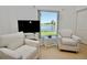 Cozy living room nook overlooking a peaceful lake, with neutral furniture at 4429 Whitton Way, New Port Richey, FL 34653