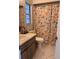 Bathroom with a floral shower curtain, vanity, toilet, and tiled floors at 5249 Courtland Rd, Spring Hill, FL 34608