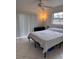This bedroom features neutral tile flooring, a ceiling fan, and a large window at 5249 Courtland Rd, Spring Hill, FL 34608