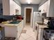 Efficient galley kitchen with white cabinetry, modern appliances, and tile flooring at 5249 Courtland Rd, Spring Hill, FL 34608