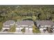 Aerial view of townhomes with manicured lawns and a scenic pond, offering a peaceful community setting at 5360 Riverwalk Preserve Dr, New Port Richey, FL 34653