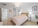 Bright bedroom with a wicker bed frame, side tables, and ample natural light, located near the staircase at 5360 Riverwalk Preserve Dr, New Port Richey, FL 34653