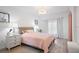 Bright bedroom with a wicker bed frame, side tables, and ample natural light from the large window at 5360 Riverwalk Preserve Dr, New Port Richey, FL 34653