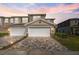 Beautiful sunset view of townhome with two car garage and a brick paver driveway at 5360 Riverwalk Preserve Dr, New Port Richey, FL 34653