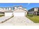 Townhome with two-car garage, paver driveway, and landscaped front yard at 5360 Riverwalk Preserve Dr, New Port Richey, FL 34653