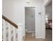 Upstairs hallway with views to a powder room and a bedroom that is tastefully decorated with neutral colors at 5360 Riverwalk Preserve Dr, New Port Richey, FL 34653