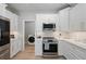 Updated kitchen featuring stainless steel appliances, white cabinets, and a view of the laundry room at 5360 Riverwalk Preserve Dr, New Port Richey, FL 34653